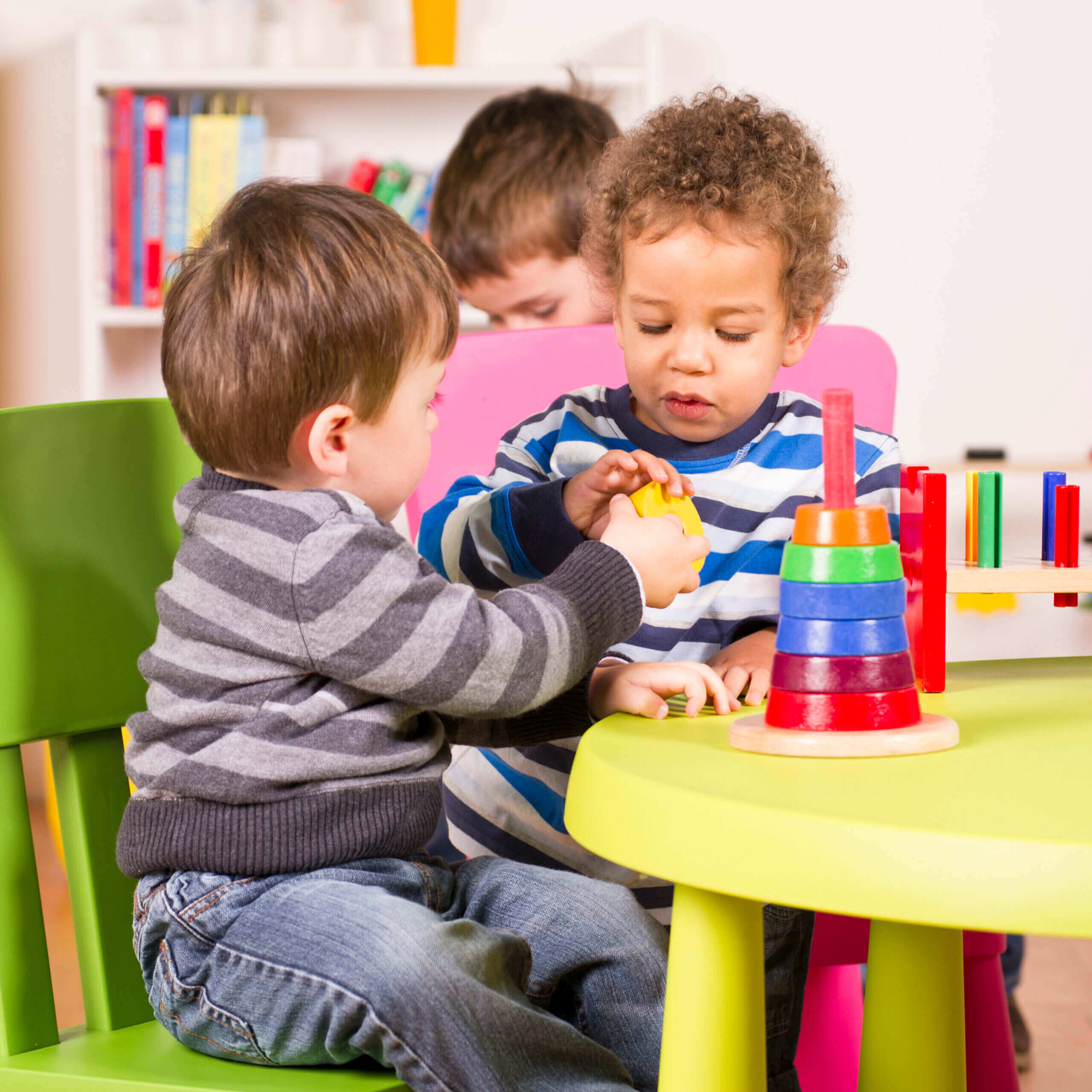Children playing with colorful toys at table.